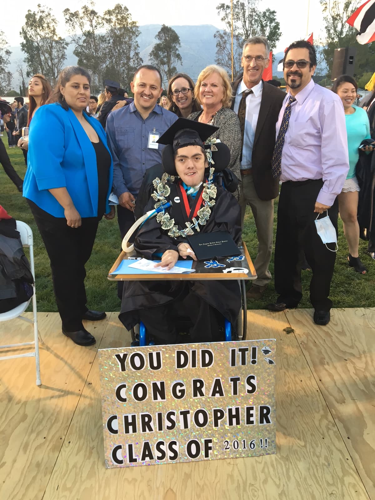 Christopher León en el día de su graduación con sus padres y educadores