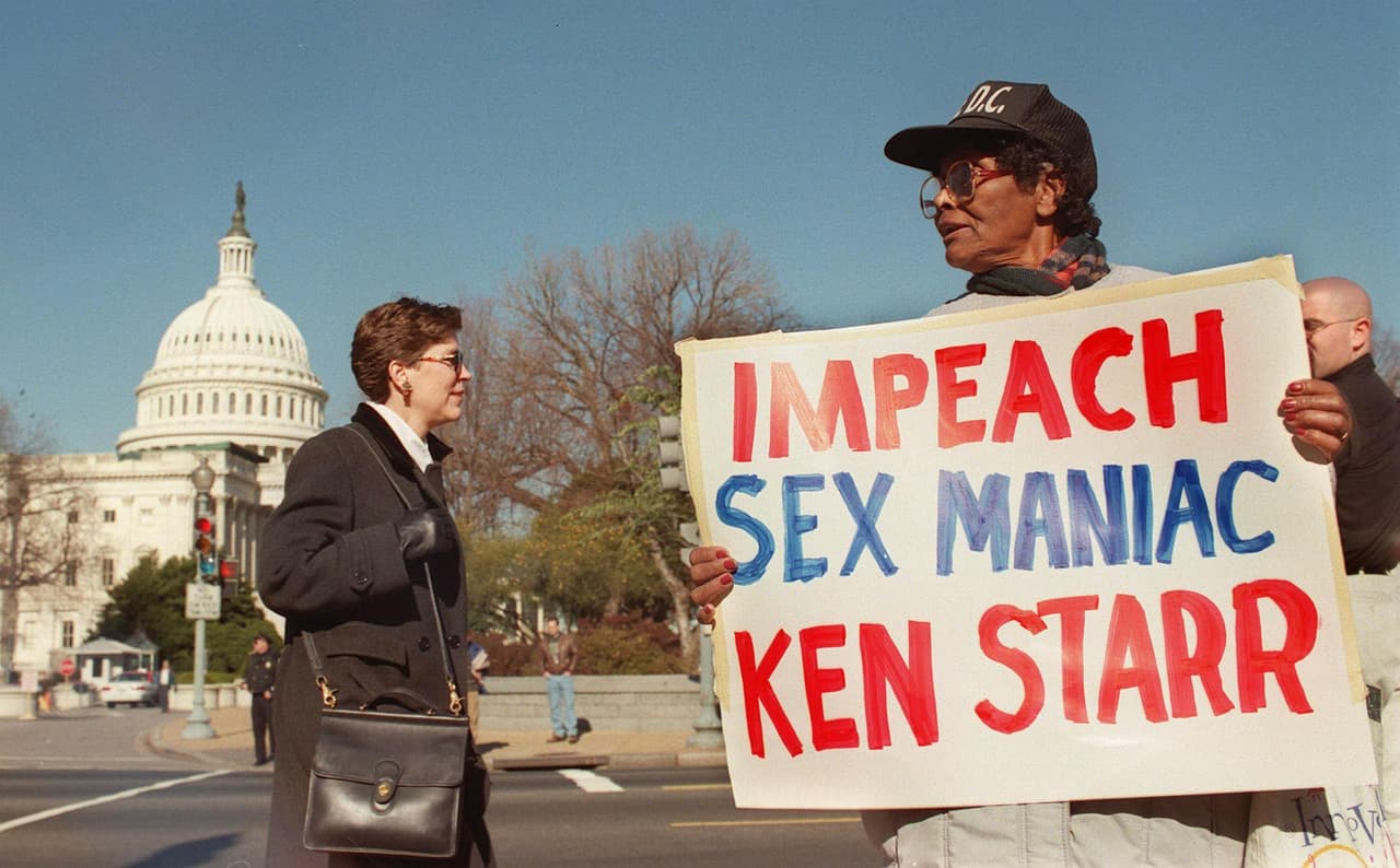 EEUU estaba siguiendo esos días muy de cerca todo lo que ocurría en el Congreso. En esta foto del 17 de diciembre, una manifestante lleva un cartel contra Ken Starr, el fiscal especial que llevó adelante la investigación sobre Clinton. El presidente fue acusado por el Congreso de mayoría republicana de "delitos graves y delitos menores" por mentir bajo juramento y obstruir la justicia para encubrir una aventura con la entonces joven Lewinsky.