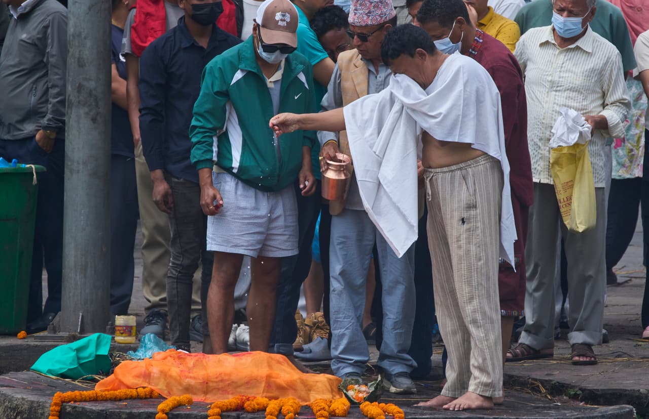 Un familiar rinde homenaje a una efigie de una persona desaparecida en las inundaciones repentinas durante un funeral simbólico a orillas del río Bagmati en Katmandú, Nepal, el jueves 3 de septiembre de 2026.