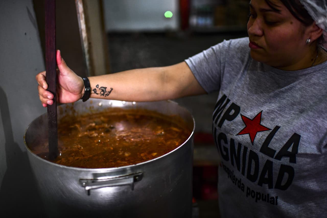 Una trabajadora del comedor 'Movimiento Popular Dignidad" cocina. A esa instalación llegan 70 familias afectadas por la crisis.