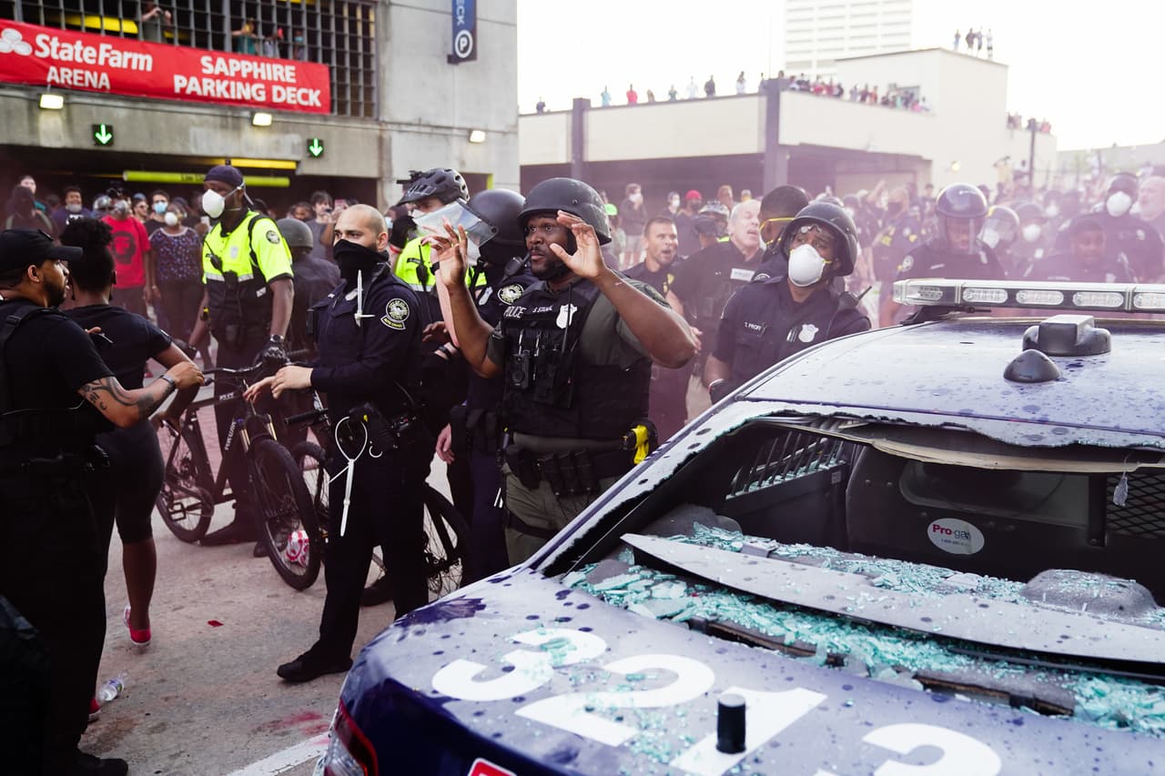 Funcionarios policiales intentan controlar la situación de violencia durante la protesta por la muerte de George Floyd.