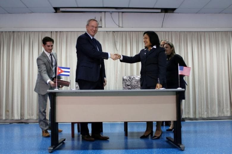 Eric Schmidt, chairman of Alphabet Inc. (C-L) and Mayra Arevich Marin (C-R), president of state telecommunications monopoly ETECSA, shake hands after signing documents in Havana, Cuba, December 12, 2016.