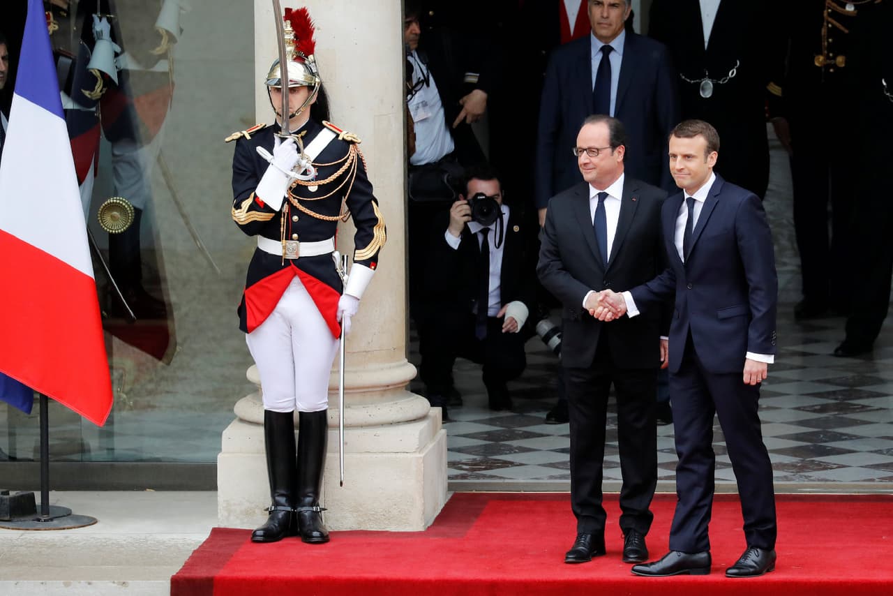 Francois Hollande, presidente saliente de Francia, estrecha la mano del nuevo jefe del gobierno francés, Emmanuel Macron
