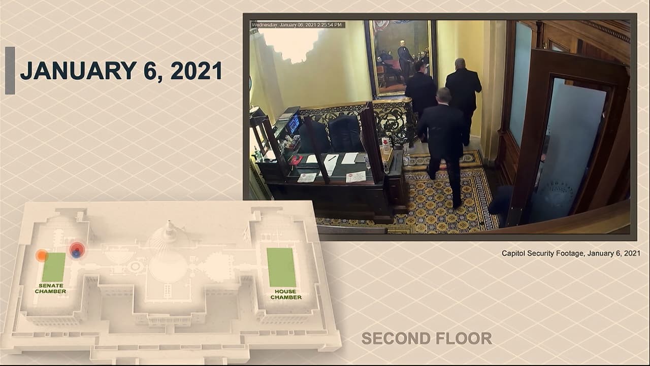En esta imagen del video, un video de seguridad muestra a los senadores que abandonan el piso del Senado mientras los alborotadores violan el Capitolio.