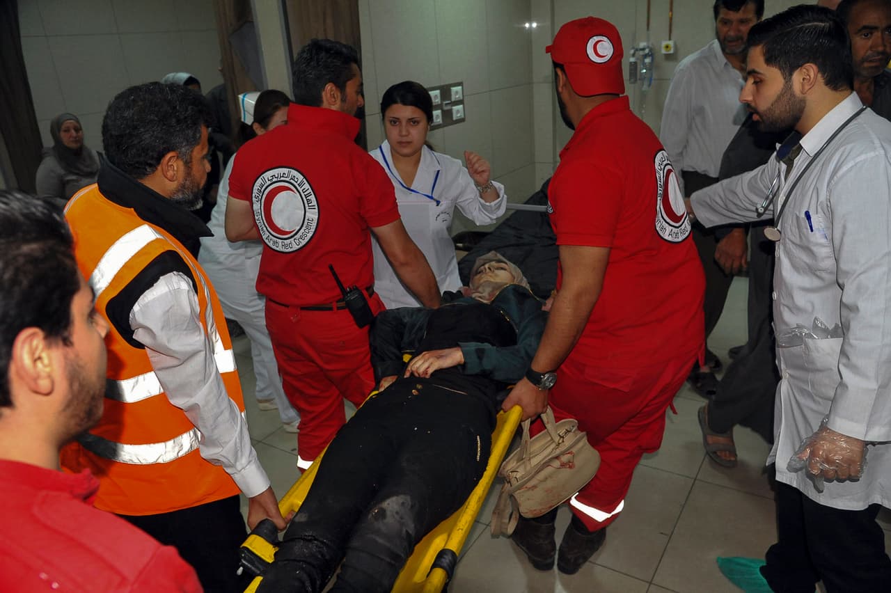 Miembros sirios de la media luna roja trasladan heridos al Hospital Al Mouwasat, donde fueron atendidos.