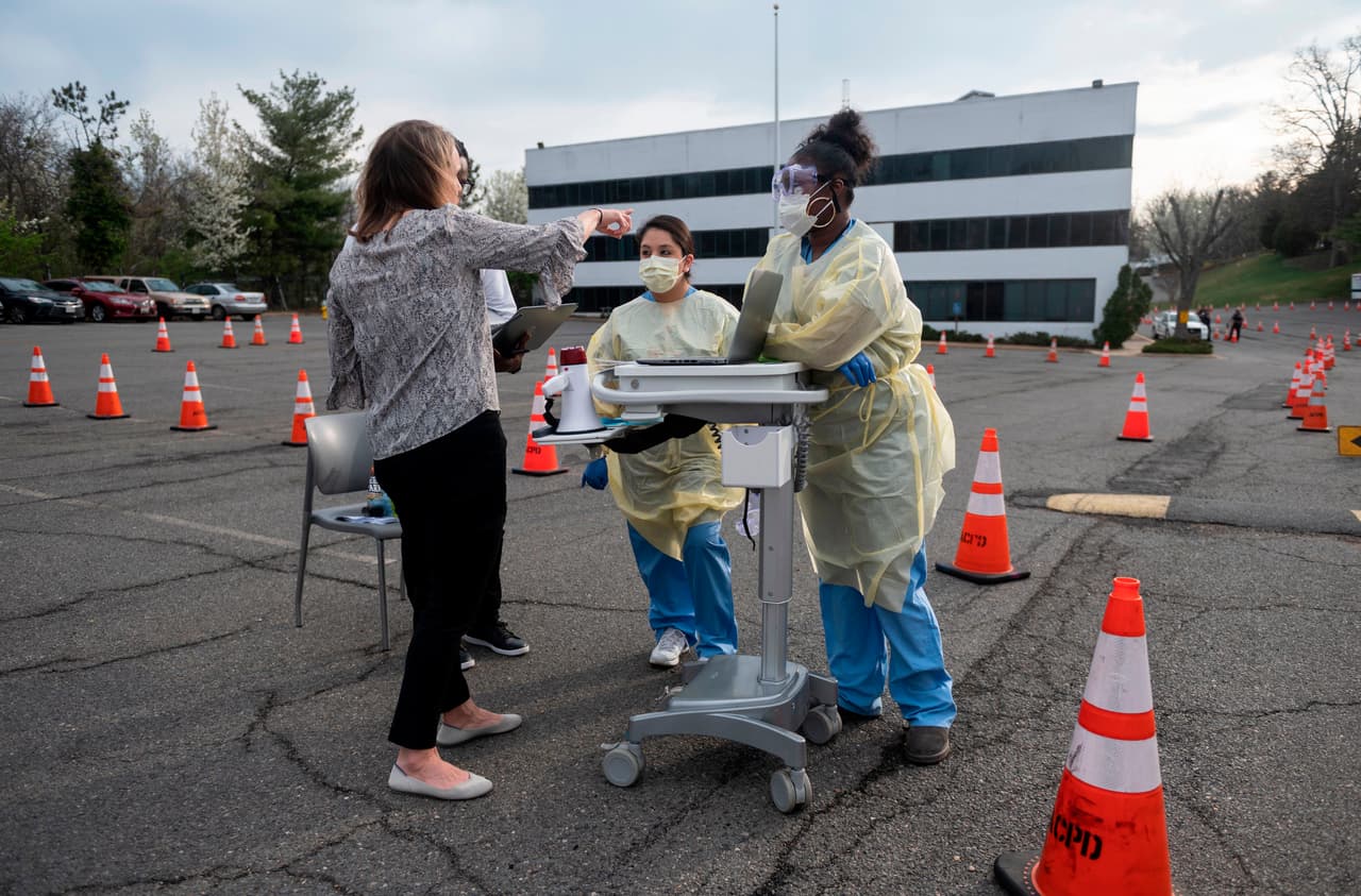 <b>Preparándose para las pruebas rápidas.</b> El personal de salud del Centro Hospitalario de Virginia se alistan para recibir y hacer pruebas a personas con síntomas del covid-19 en Arlington, Virginia, el 20 de marzo.
