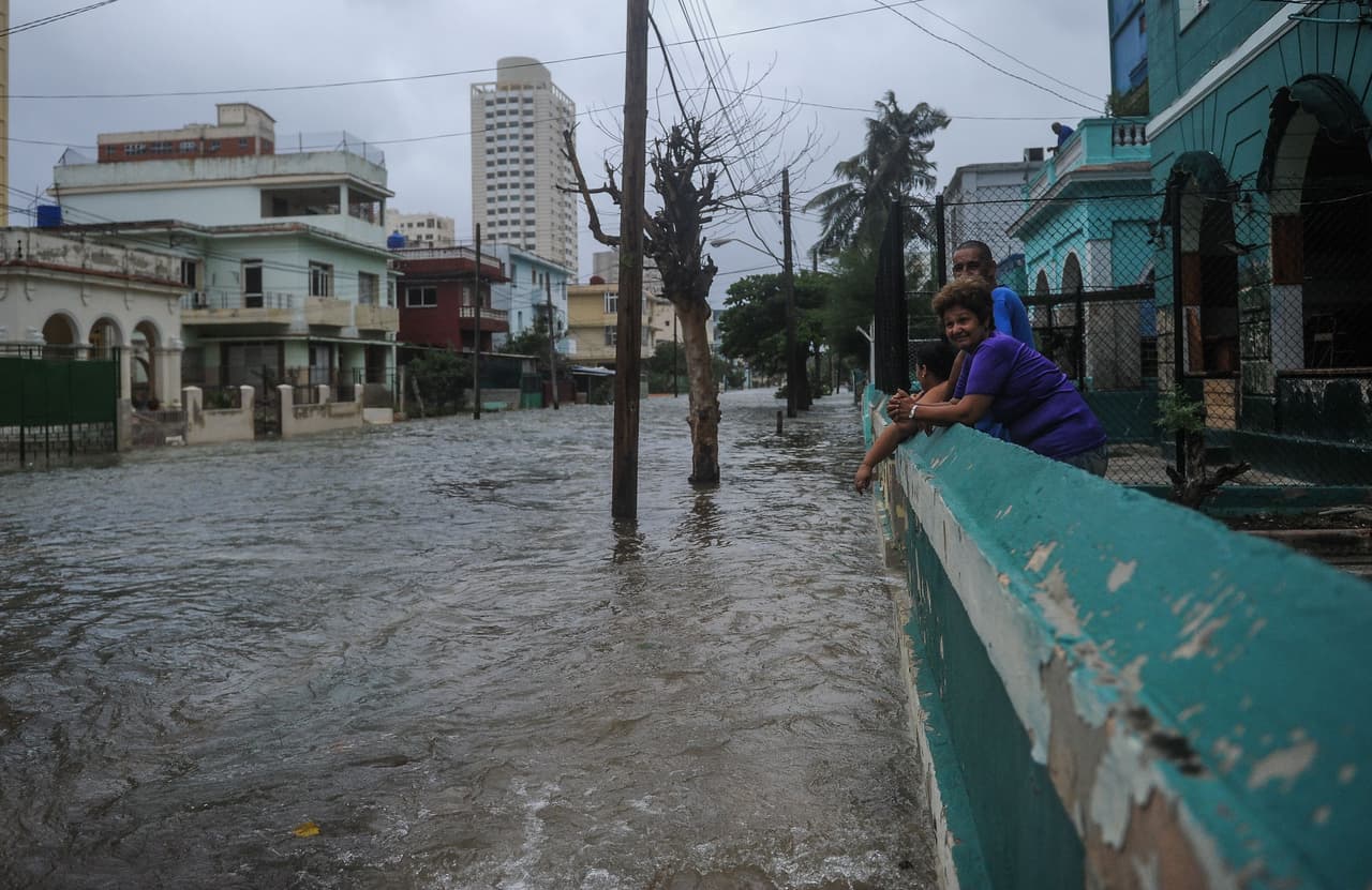 Luego de horas de lluvia, residentes de la Habana miran la inundación en las calles.