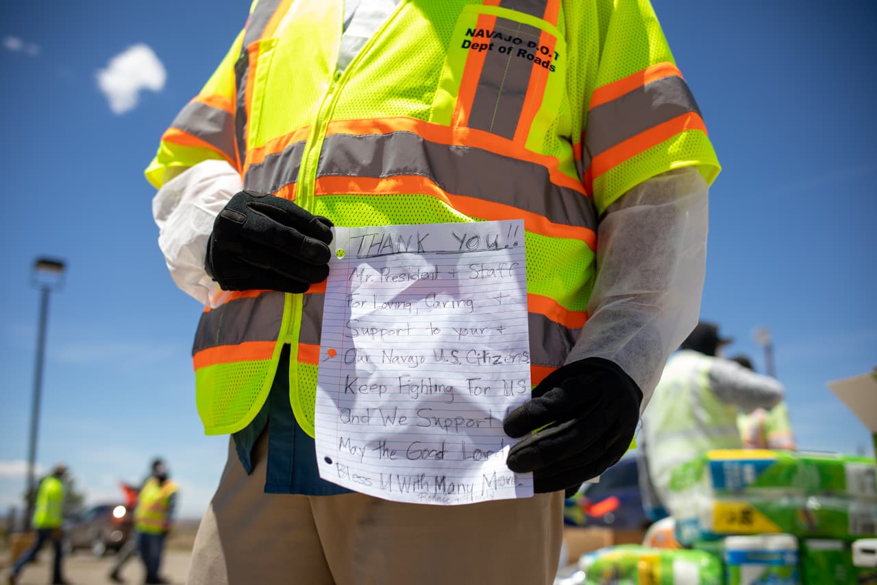 El presidente de la Nación Navajo, Jonathan Nez, sostiene una carta de una familia navajo mientras distribuía alimentos, agua y otros suministros el 27 de mayo de 2020 en Huerfano, parte de la Reserva de la Nación Navajo, en Nuevo México.