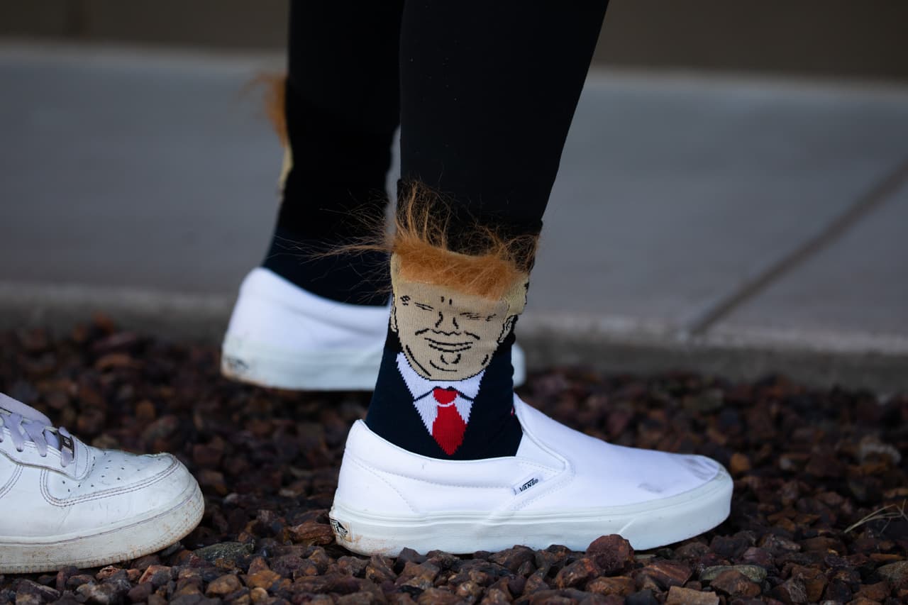 La gente espera para subir a un autobús que los llevará a un mitin de campaña del presidente Donald Trump, este 19 de octubre de 2020 en Prescott, Arizona. Con casi dos semanas para las elecciones de noviembre, el presidente Trump está de regreso en la campaña con múltiples eventos diarios. Más tarde, viajará hacia Tucson.