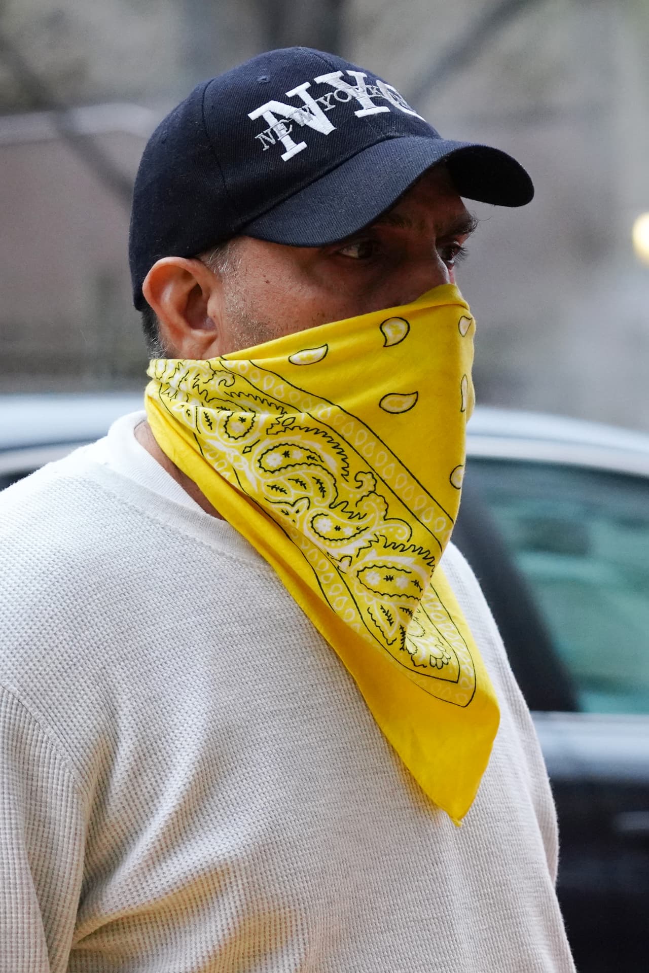 Un hombre lleva usa bandana amarilla como cubierta para la cara