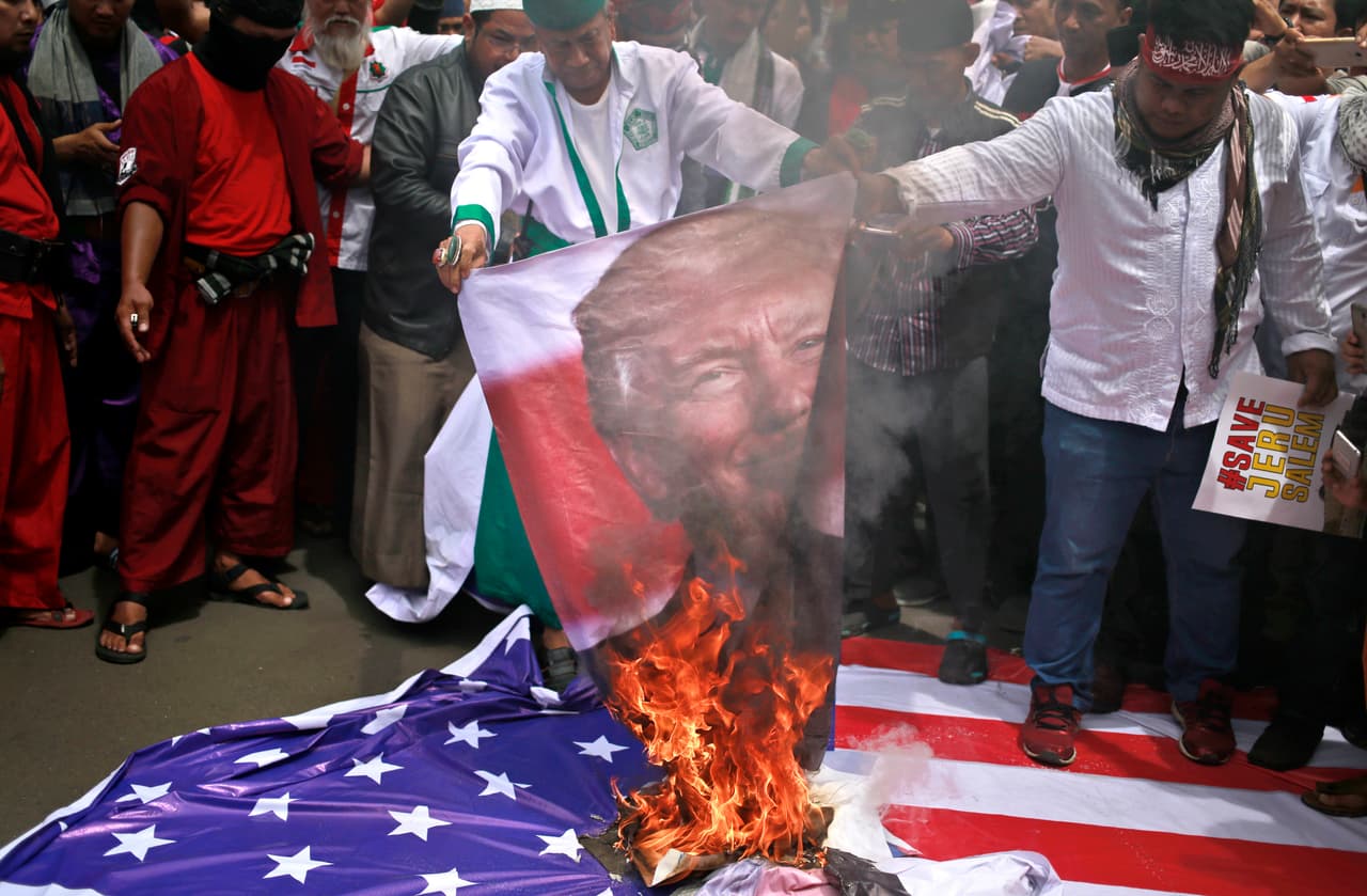 Manifestantes queman un cartel con la imagen del presidente de Estados Unidos, Donald Trump, durante una protesta en el exterior de la embajada de Estados Unidos en Yakarta, Indonesia, el 11 de diciembre de 2017. Cientos de personas se manifestaron en la capital del país contra la decisión de Trump de reconocer a Jerusalén como la capital de Israel. (AP Foto/Dita Alangkara)