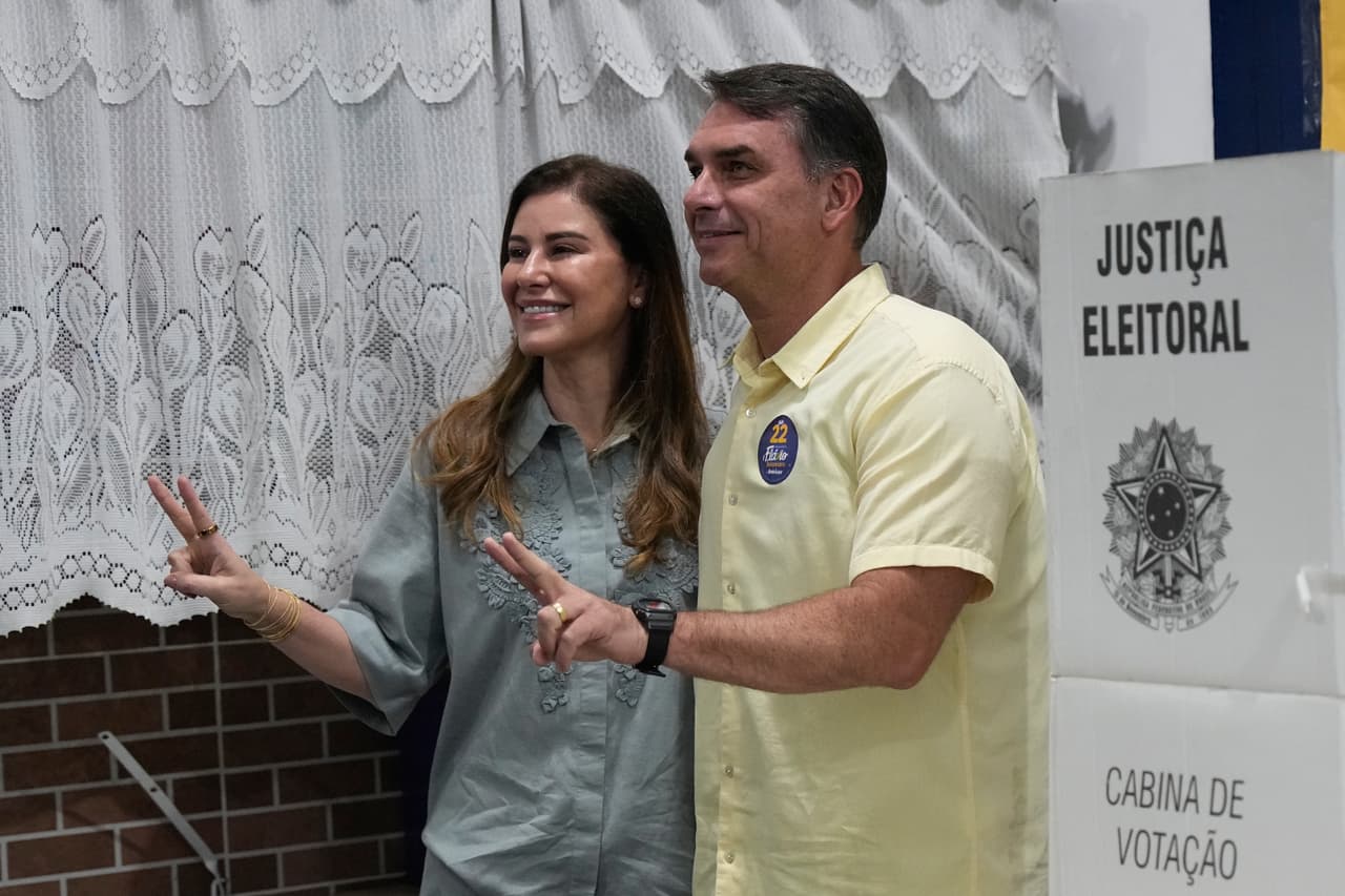 El candidato presidencial de la oposición, el senador Flavio Bolsonaro, y su esposa, Fernanda, levantan el pulgar en señal de aprobación durante la segunda vuelta de las elecciones presidenciales en Río de Janeiro, el domingo 25 de octubre de 2026.