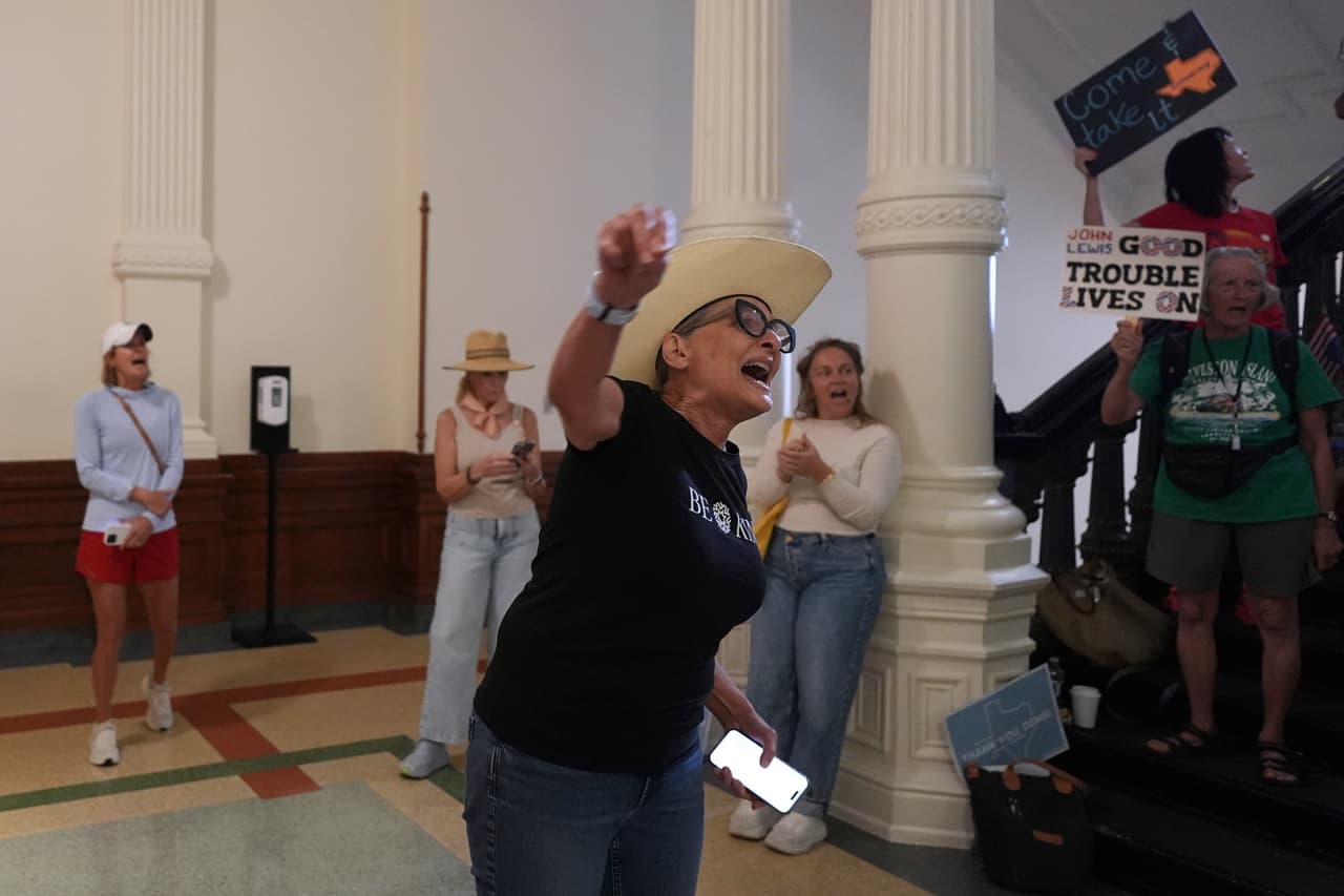 Sam Parker lidera a otros manifestantes en un cántico frente a la Cámara de Representantes, donde la diputada demócrata de Texas Nicole Collier se niega a abandonar el lugar debido a la necesidad de contar con escolta policial.