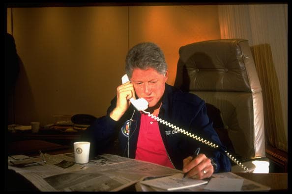 El expresidente de Estados Unidos
<b> Bill Clinton fue el mandatario número 42 y el tercero más joven del país.</b> Su mayor logro fue haber dejado las arcas públicas con un superávit de casi 600,000 millones de dólares y una popularidad del 76%, la más alta de la postguerra. Un escándalo sexual casi lo saca de la Casa Blanca tras ser perdonado por el Senado en un juicio político por perjurio, es decir, haber mentido bajo juramento al afirmar que no tuvo una relación sexual con la pasante Monica Lewinsky. En la imagen se le ve tomar notas con su mano izquierda mientras realiza una llamada telefónica.