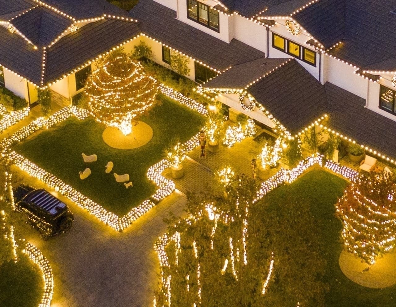 Desde las alturas y durante el atardecer, la iluminación amarilla se apodera de las inmediaciones de su propiedad. El furor festivo queda de manifiesto en todos los techos de la mansión, así como en los árboles y jardines.