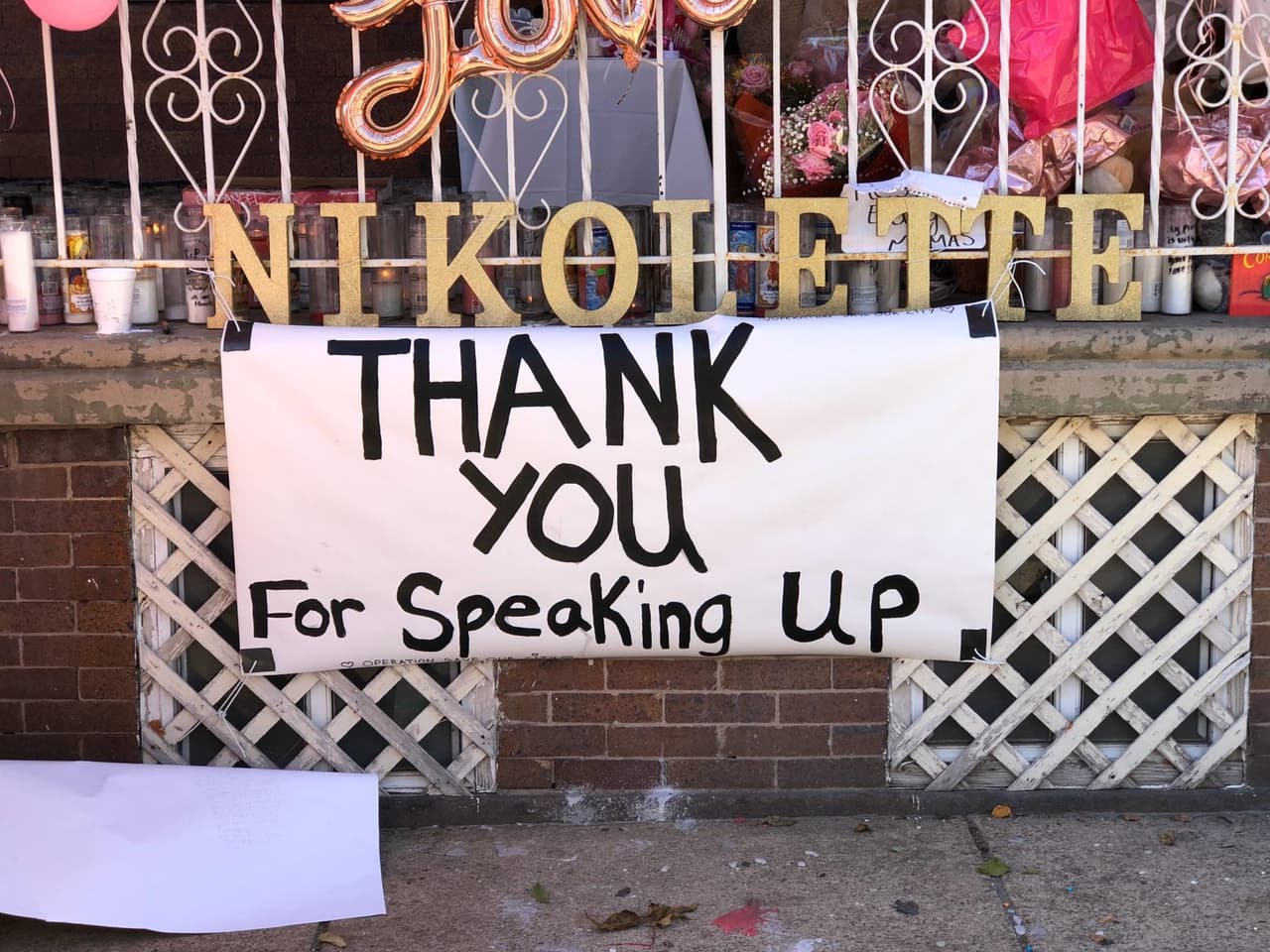 <br>Un letrero que cuelga afuera de la casa de la familia de la víctima, frente al monumento en rosa y blanco, dice: "Gracias por hablar".
<br>