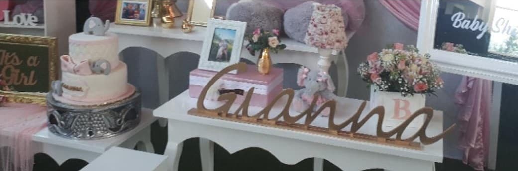 Esta fue la mesa de regalos que fue adornada con flores, velas, pastel rosa y el nombre de la niña con letras doradas, entre otros detalles.