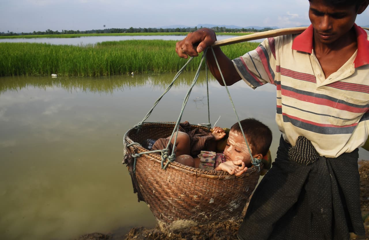 Cientos de aldeas rohingyas en Myanmar han sido arrasadas, las tierras expropiadas y los cultivos destruidos. En la fotografía, un padre y su hijo rohignya en camino al refugio de Bangladesh el 2 de noviembre de 2017.
<br>