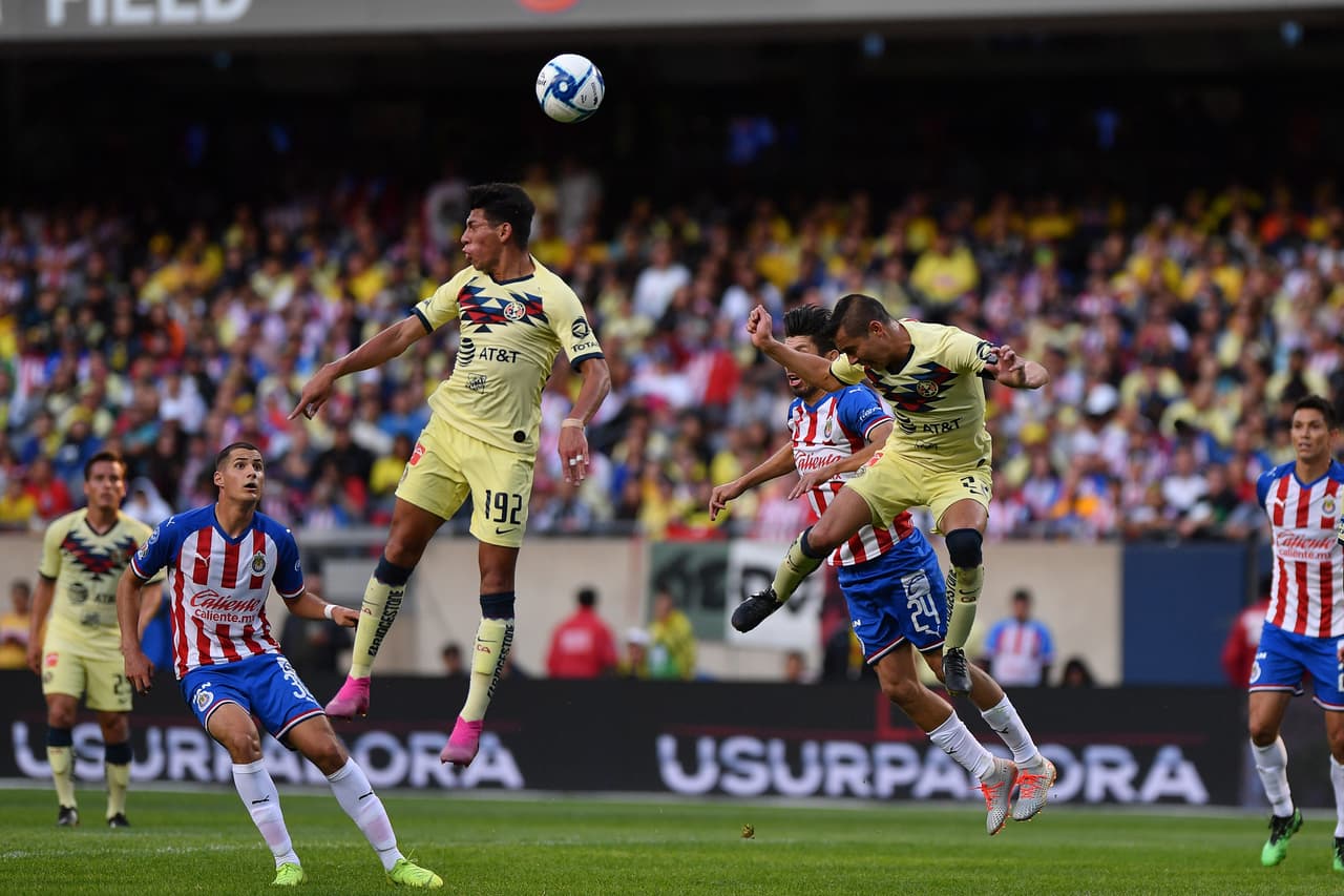 Centro de Chivas, Paul Aguilar llega antes que Oribe Peralta, con quien lucha en el aire.