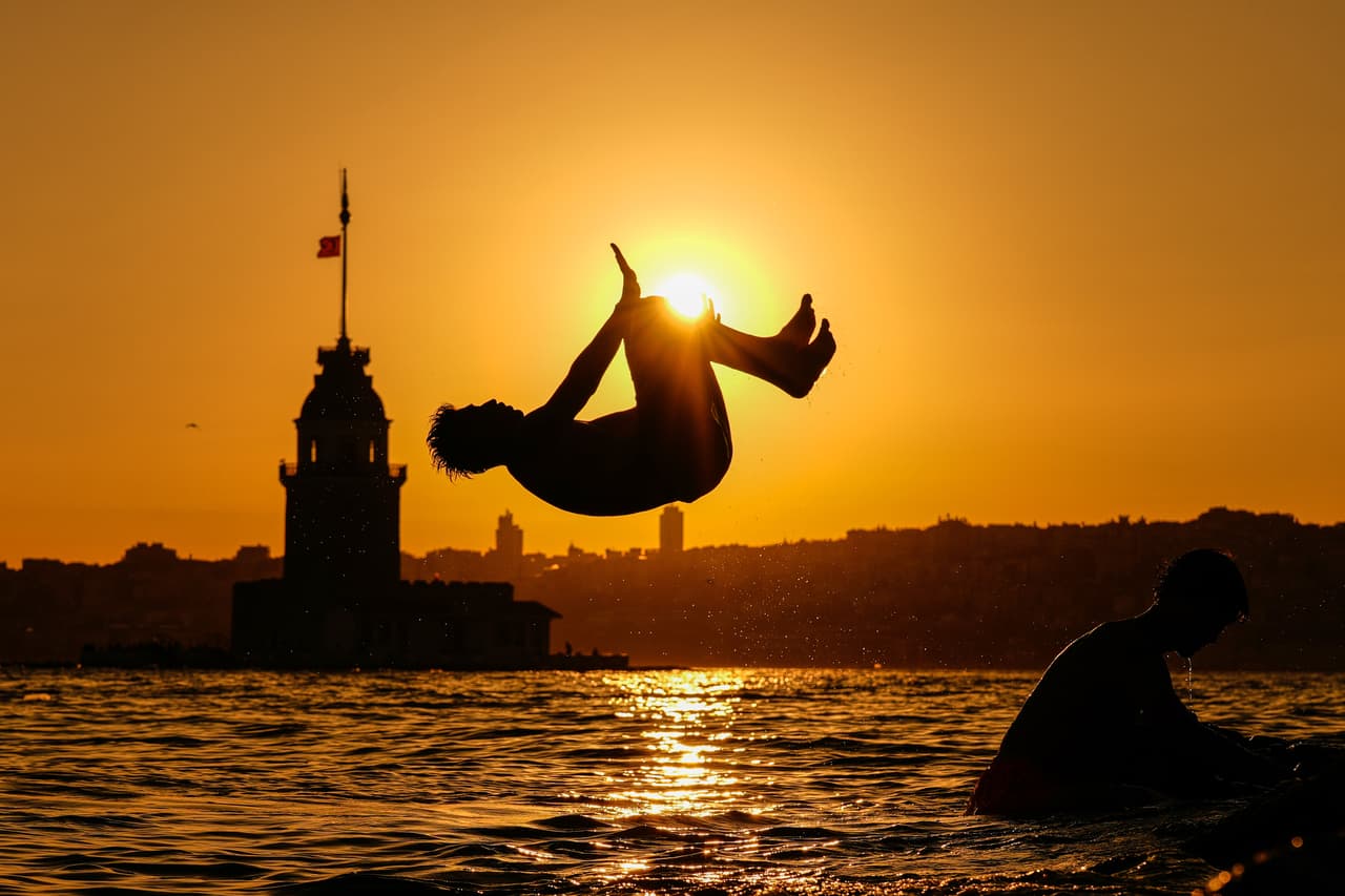 Turcos se lanzan a las aguas del estrecho del Bósforo, que divide Europa y Asia, para mitigar las altas temperaturas provocadas por la intensa ola de calor que afecta a Estambul.