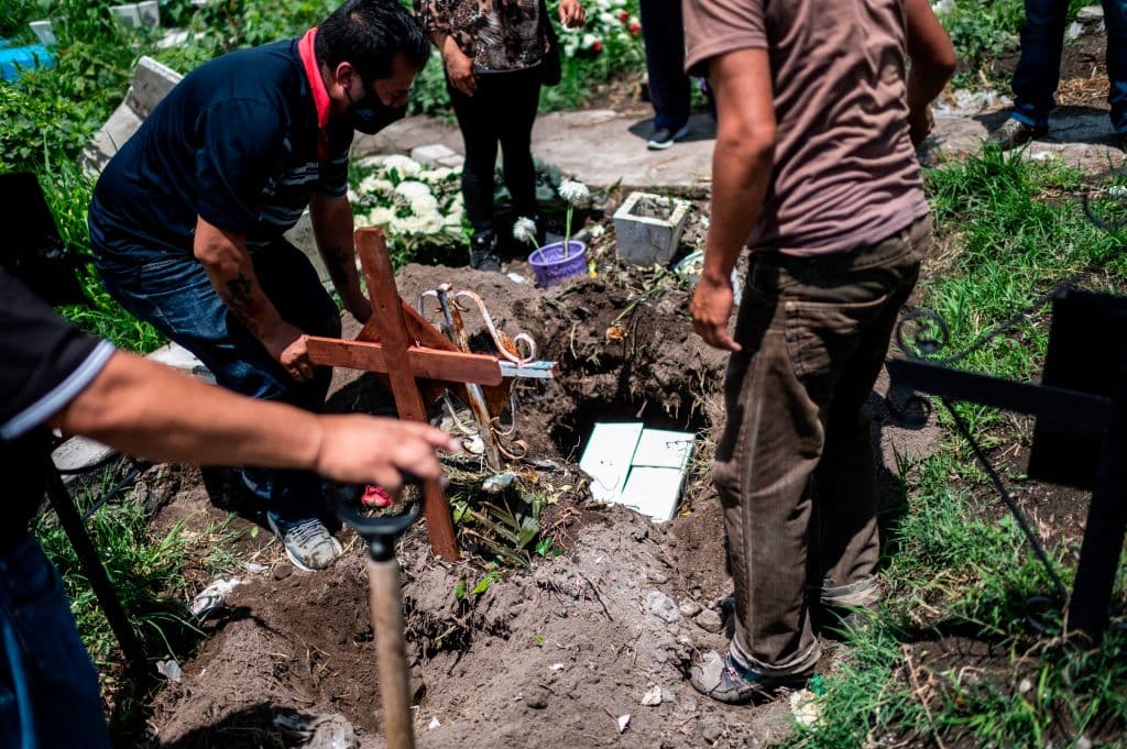 Familiares entierran las cenizas de un fallecido en el cementerio de San Miguel Xico el 5 de agosto de 2020, en medio de la pandemia.
<br>