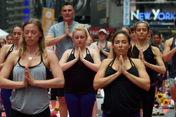 Practicantes de Yoga en Times Square. Muchos creen que el yoga, una forma antigua de ejercicio, es la mejor manera de tranquilizar la mente y la mejor manera de dinamizar al cuerpo.
