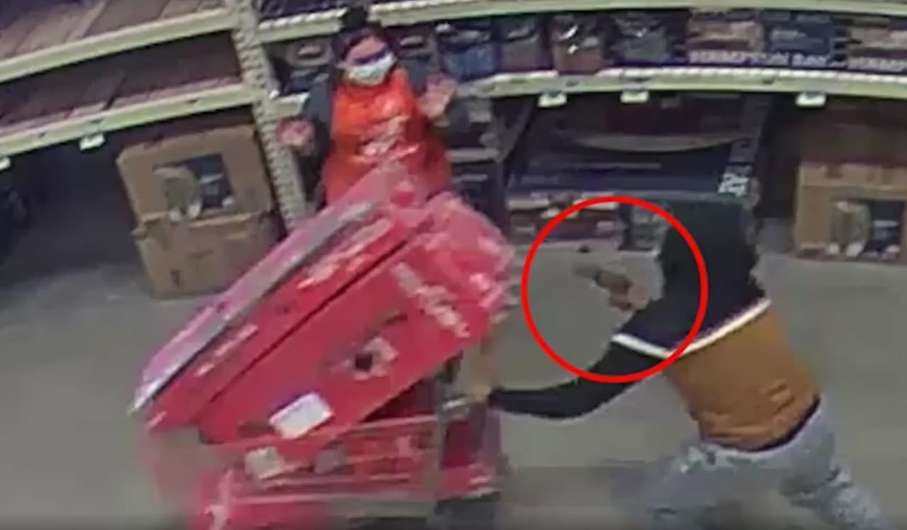 Un ladrón apunta con un arma a la empleada de una tienda departamental.