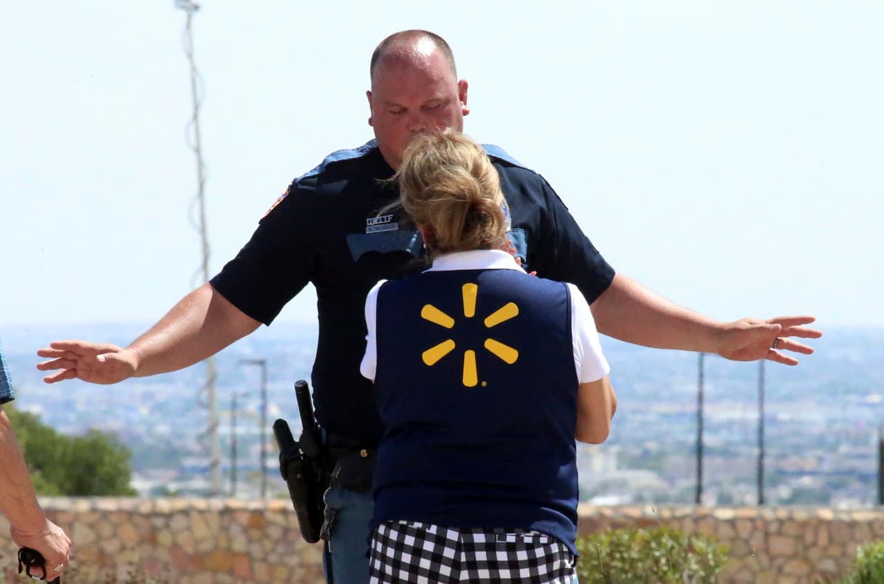 Un oficial de la policía de El Paso conversa con una empleada de Walmart, tras el tiroteo ocurrido en la tienda, ubicada en el centro comercial de la ciudad fronteriza.