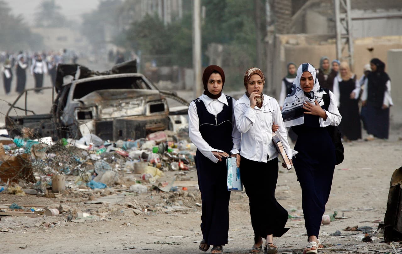 <b>Irak.</b> Unas jóvenes caminan a través de los escombros de la guerra hacia a su escuela de Bagdad. 12 de noviembre de 2007.