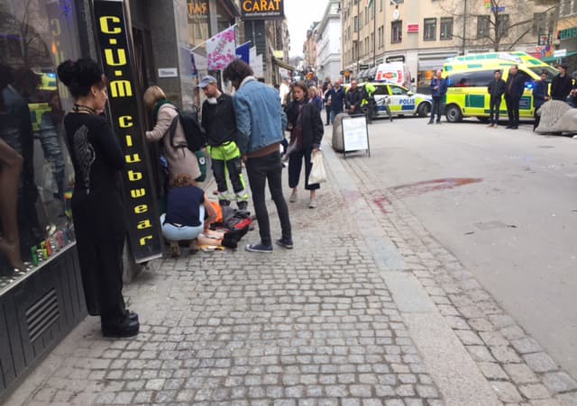 Una persona herida es atendida en la calle.