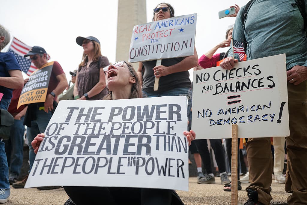 <b>Preocupaciones por la violación de derechos civiles</b>: Una pancarta afirma: "El poder del pueblo es más grande que las personas en el poder". Las manifestaciones se enfocan en lo que se considera un ataque a los derechos civiles bajo la administración Trump, especialmente en relación con la deportación masiva de inmigrantes y el despido de empleados federales.