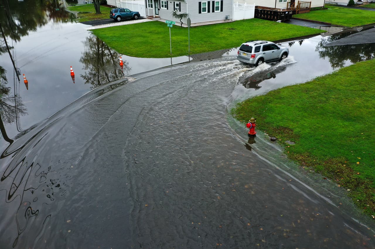 Aproximadamente 90,000 personas se quedaron sin electricidad en el estado de Rhode Island. La fotografía muestra a un auto conducido por una calle inundada en Middlesex, Nueva Jersey.