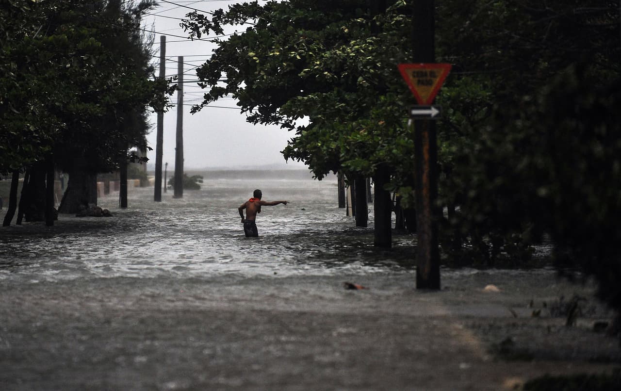 Un hombre camina por la Habana, en plena lluvia. 
<br>