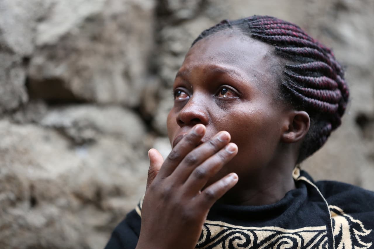 Una mujer observa las labores de emergencia en la construcción que cedió luego de las fuertes precipitaciones que azotaron a Nairobi. Foto de Reuters.