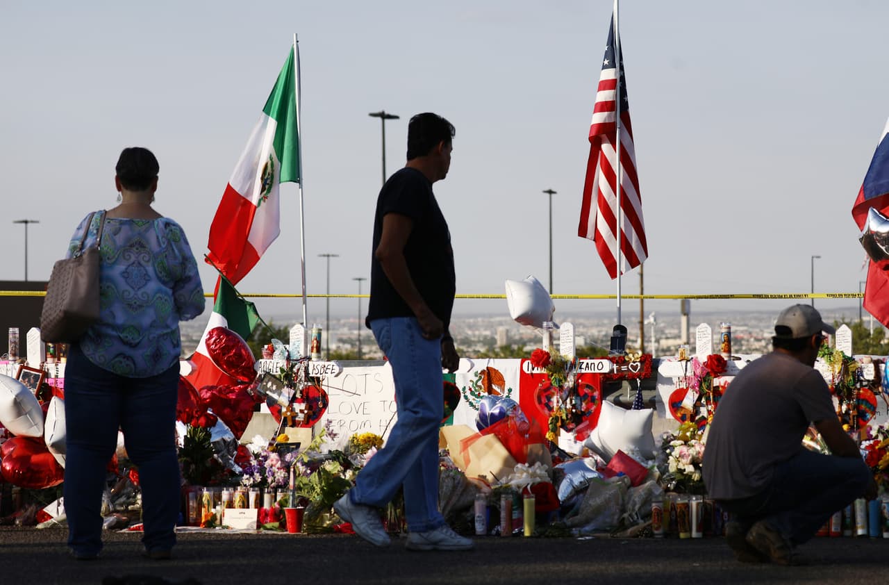Las banderas de México y EEUU ondean sobre un altar en honor a las víctimas afuera del Walmart en El Paso donde ocurrió el tiroteo que dejó 22 muertos, ocho de ellos mexicanos.