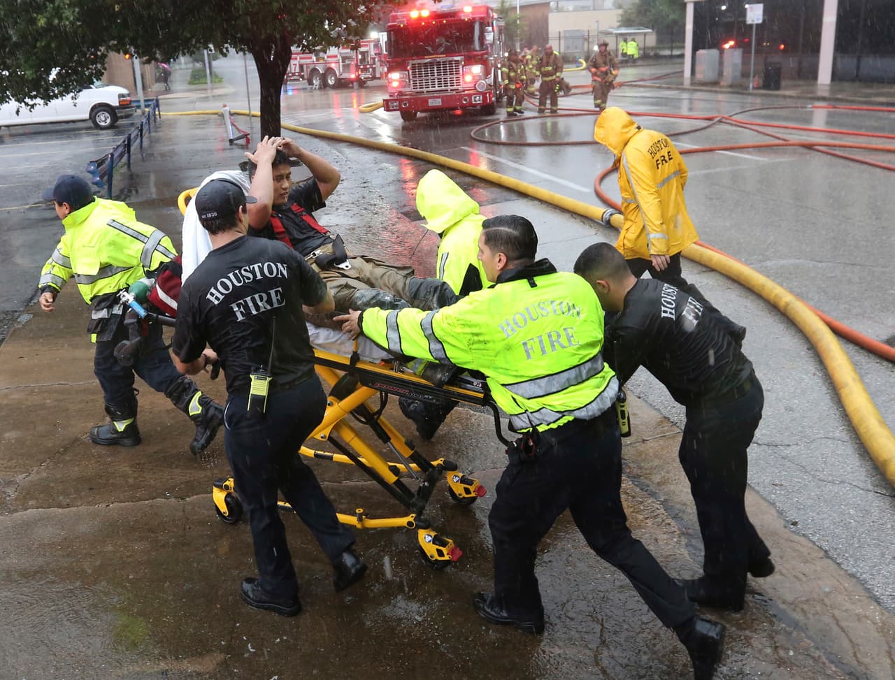 Un bombero es asistido por sus compañeros en el centro de Houston. Estuvo ayudando a combatir un incendio en un edificio de oficinas.
