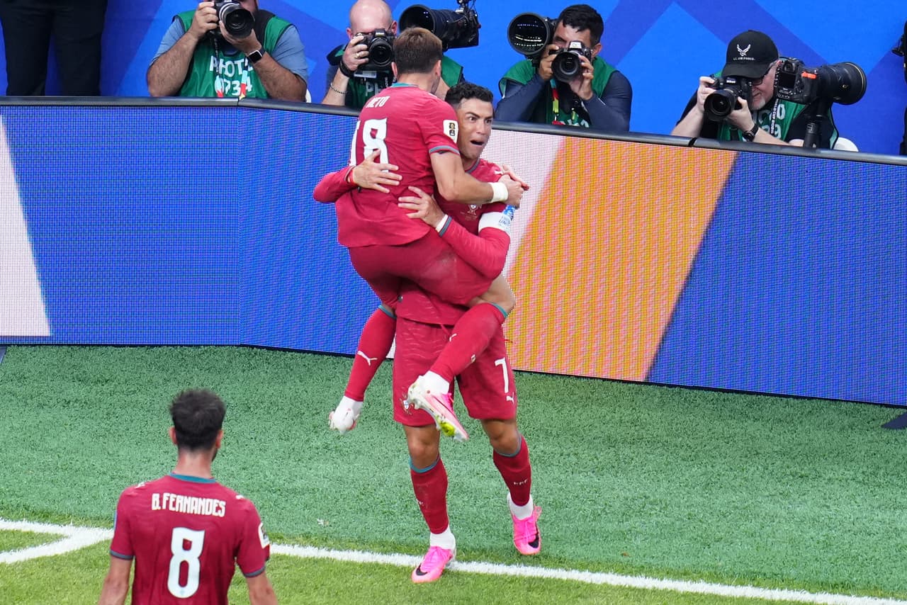 Cristiano Ronaldo (7), de Portugal, celebra con Pedro Neto (18), también de Portugal, después de que Ronaldo anotara el tercer gol de su equipo durante el partido de fútbol del Grupo K de la Copa Mundial entre Portugal y Uzbekistán