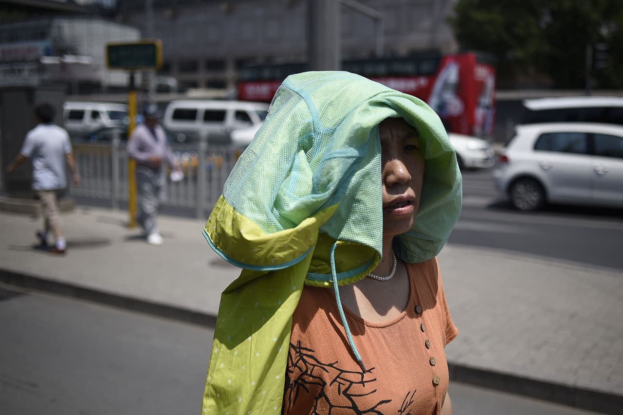 Si la temperatura corporal del cuerpo se mantiene elevada por mucho tiempo, la hemoglobina tiene más problemas para fijar el oxígeno y comienza a faltarnos la respiración. Esta es una residente China, por la calle.