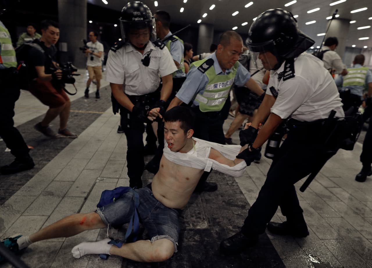 Agentes de la policía arrastran a este manifestante que participaba la mañana de este lunes en una manifestación frente al Consejo Legislativo de Hong Kong, contra el proyecto de ley de extradición.