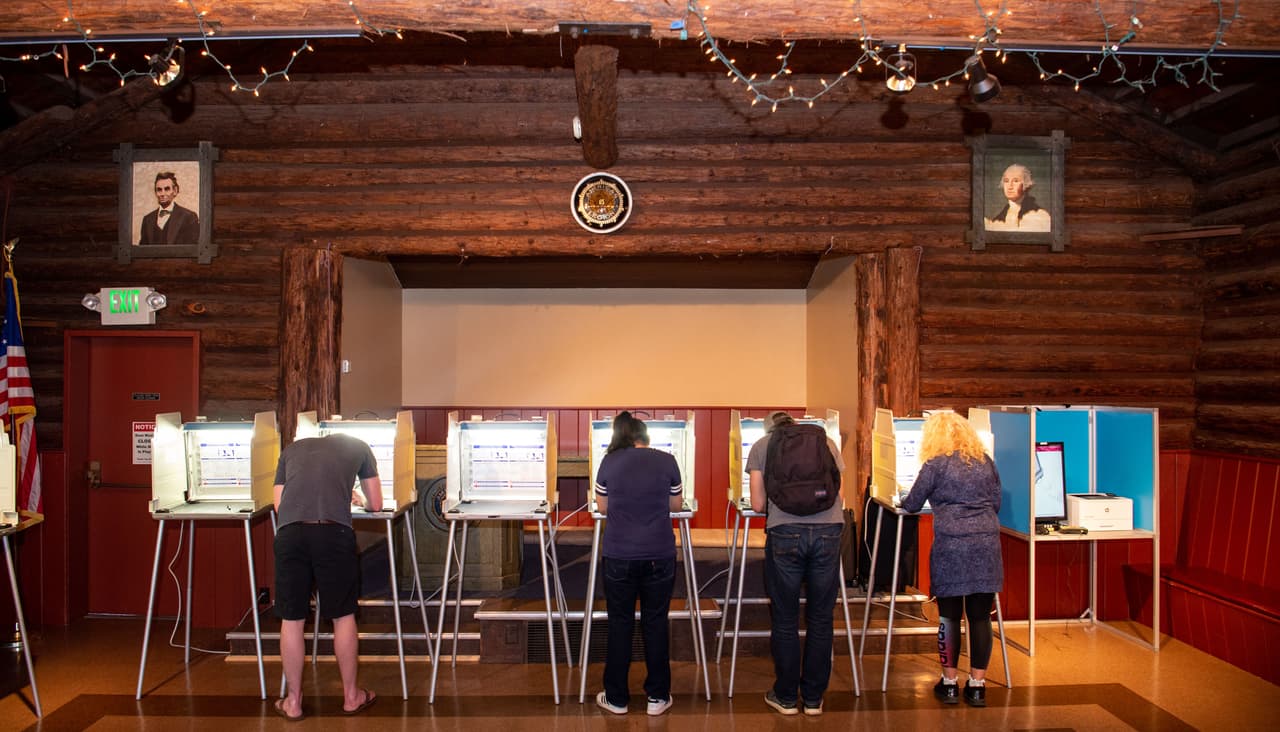 Algunos ciudadanos votan en San Anselmo, California, ante los retratos de George Washington y Abraham Lincoln.