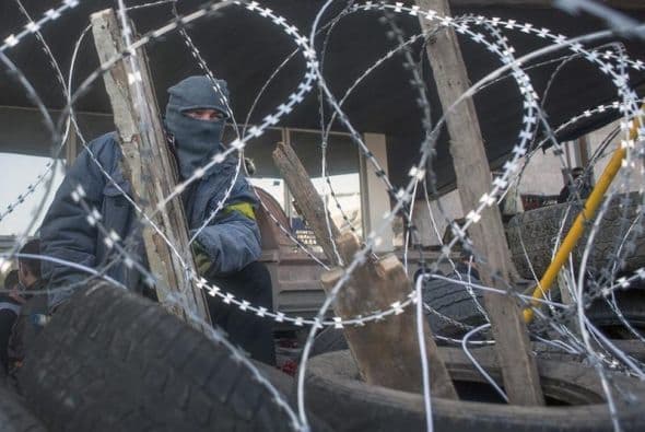 Manifestantes prorrusos permanecen junto a una barricada en un edificio ocupado de la administración regional en Donetsk.