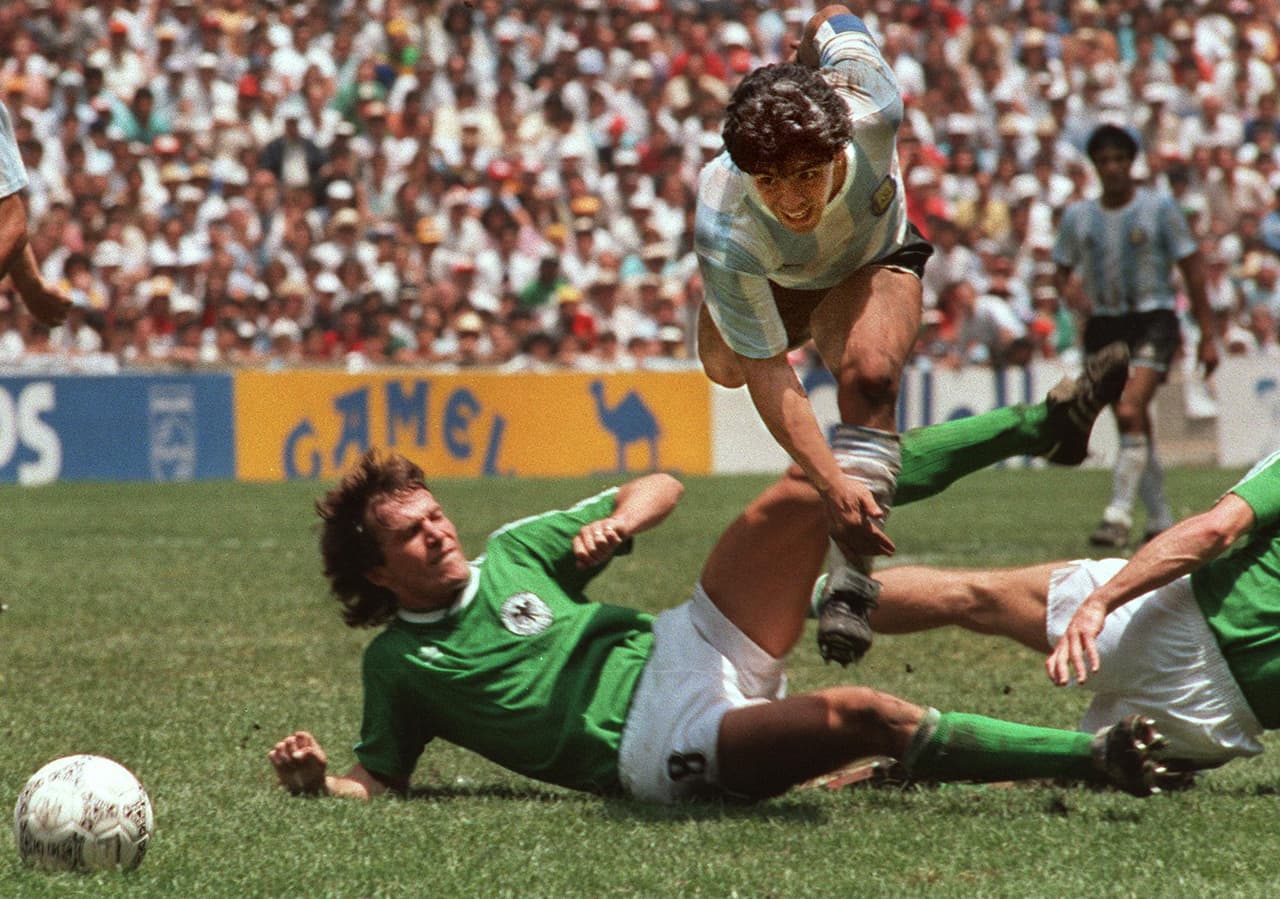 Argentina's soccer star team captain Diego Maradona evades a tackle from West Germany's Lothar Matthaus during the World Soccer Cup final, won by Argentina's team after a 3-2 victory over West Germany, 29 June 1986 at the Azteca stadium in Mexico City. (Photo credit should read STAFF/AFP/Getty Images)