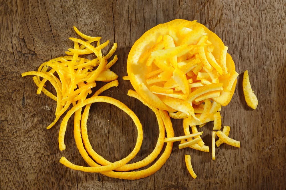 Por encima de los pétalos, esparce la ralladura de naranja, cubriendo también la mayor parte posible del centro de tu corazón.