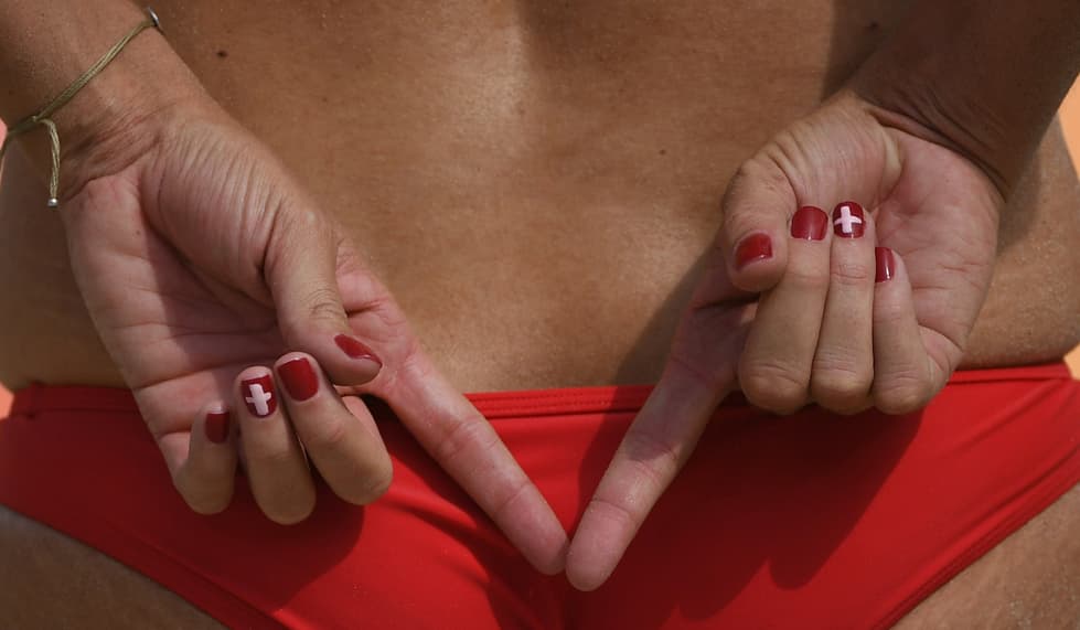 Isabelle Forrer presume su manicure con una uña decorada como la bandera de Suiza y el resto de color rojo. Aquí las presume mientras le hace señas a su compañera de equipo de voleibol de playa.
