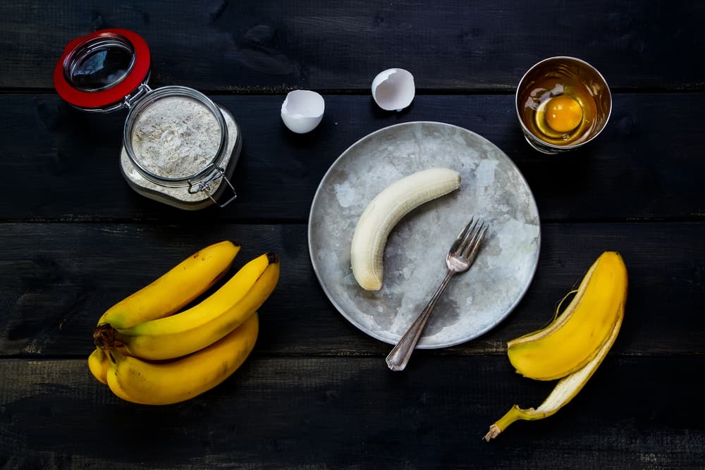 Comienza precalentando el horno a 180°C y coloca la charola en la mitad, forra 2 charolas para hornear con papel pergamino. Mientras en el vaso de la licuadora coloca la avena, los plátanos y el coco y procesa.