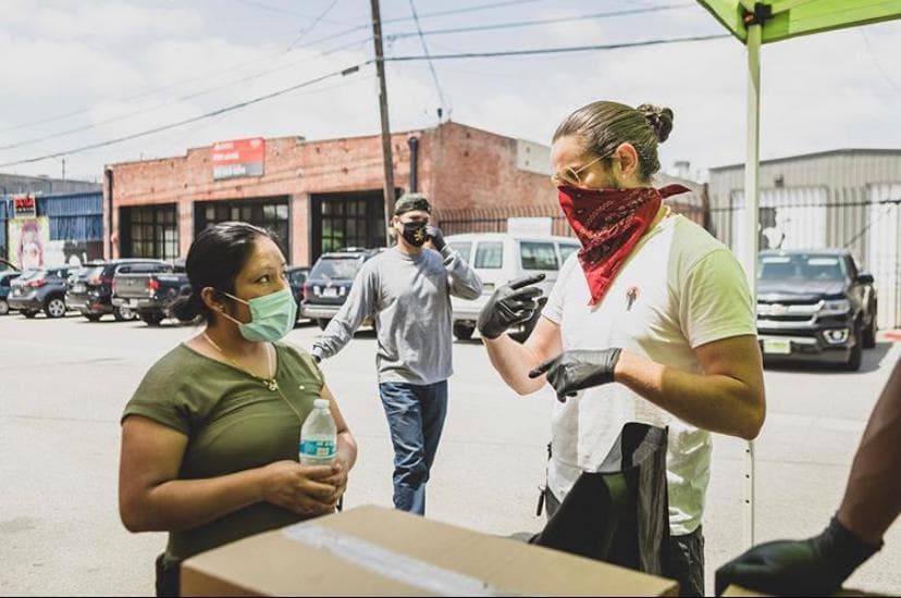 “Aquí tenemos variedades de frutas y vegetales, abajo hay leche”, dice Damián Díaz uno de los fundadores de la organización sin fines de lucro, a una beneficiaria que viene por su despensa de comida cada ocho días.