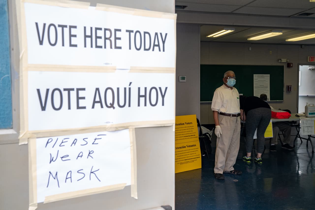 Un trabajador electoral en el centro de votación de Liberty High School el 7 de julio en Jersey City, Nueva Jersey. Los votantes pueden asistir personalmente a los centros de votación. Sin embargo, las autoridades electorales enviaron boletas por correo a 2.3 millones de demócratas registrados, 1.3 millones de republicanos y 2.4 millones de votantes registrados sin afiliación política.