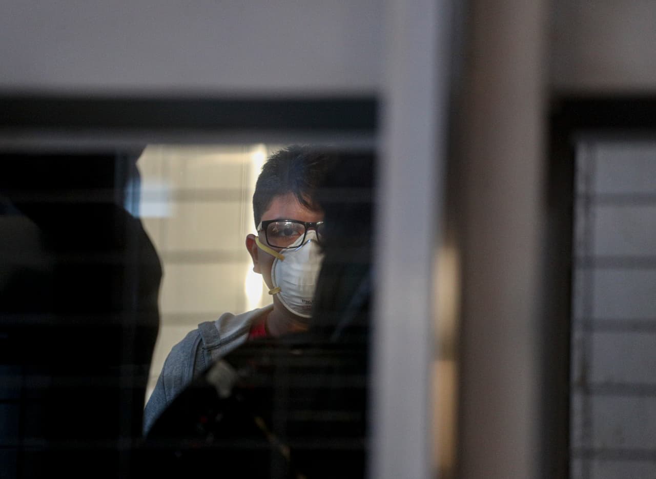Un pasajero con una mascarilla usa un elevador antes de abordar un vuelo en el Aeropuerto Internacional Arturo Benítez en Santiago, Chile, 3 de marzo de 2020.