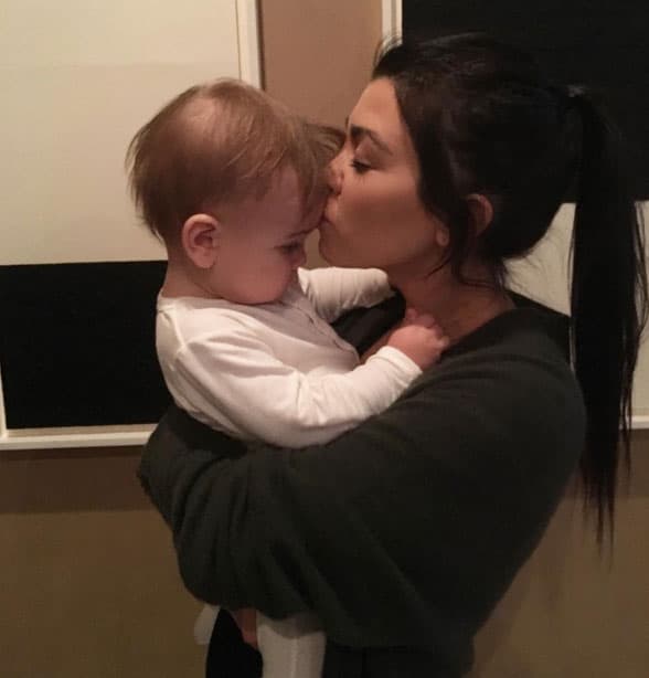 Kourtney Kardashian dando su besito de Año Nuevo a Reign.