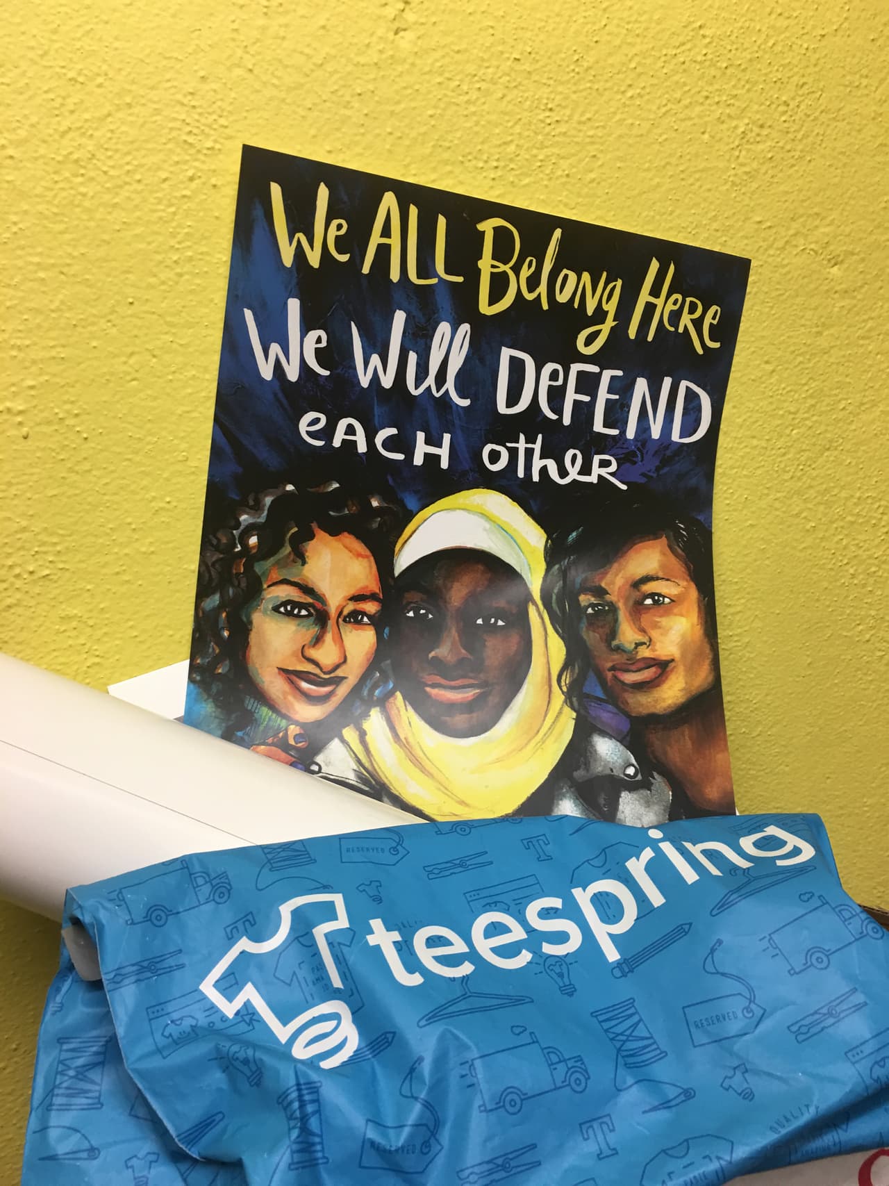 Algunas de sus pertenencias están flanqueadas por afiches como este en el que se puede leer: "We all belong here. We will defend each other (Todos pertenecemos a este lugar. Nos defenderemos unos a otros)". (Patricia Vélez/Univision Noticias)
